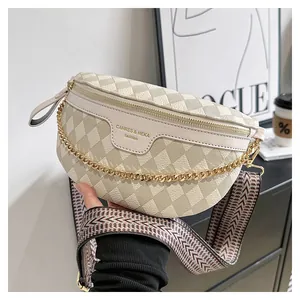 Detail of beige quilted waist bag with gold chain and patterned wide fabric strap