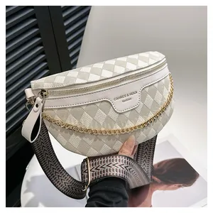 Detail of cream white faux leather waist bag with quilted texture and gold chain decoration