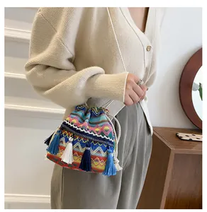 Détail d'un sac seau bohème avec textures tissées colorées et décorations de franges