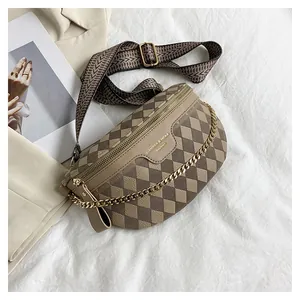 Detail of a chic crossbody bag with chevron strap and gold chain on beige fabric
