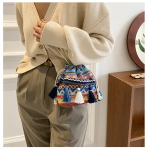 Gros plan d'un sac seau bohème tissé avec motifs géométriques colorés et détails à franges