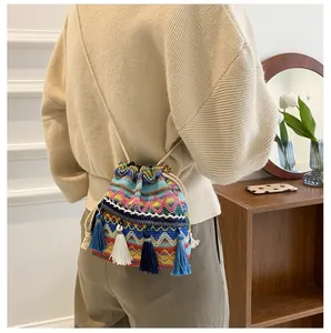 Détail du sac seau tissé bohème avec des glands à franges colorés et motifs de vagues