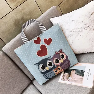Dettaglio ricamo famiglia di gufi su borsa tote intrecciata azzurra con strisce