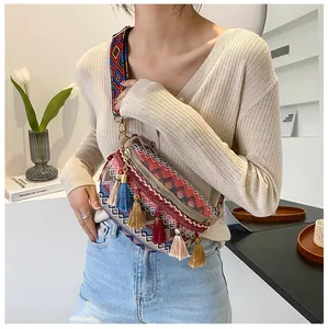 Detail of bohemian cross-body bag with ethnic patterns and colorful fringe tassels