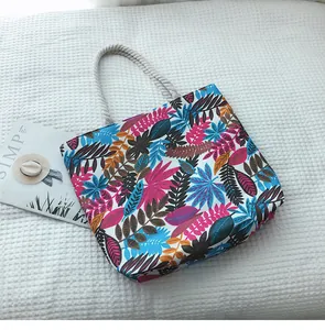 Détail du sac fourre-tout en toile à motif de feuilles tropicales avec poignées en corde