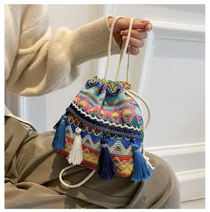 Détail du sac seau ethnique tissé avec motifs géométriques colorés et longues franges