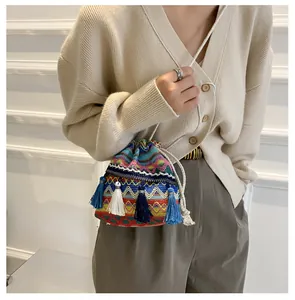 Détail du sac seau tissé coloré avec motifs ondulés et longs glands à franges bleues