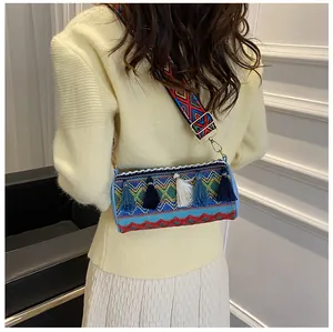 Rear view of woven cylinder bag with colorful tassels and geometric wide strap