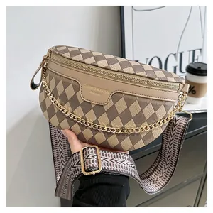 Detail der beige-braun gesteppten Crossbody-Tasche mit Goldkette und breitem Gurtband