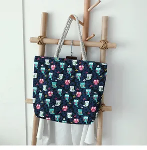 Vue détaillée d'un grand sac en toile bleu marine avec motifs hiboux et anses en corde