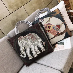 Dettaglio di borse tote jacquard bohémien con motivi intrecciati di elefanti e gufi