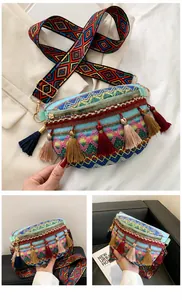 Detail view of ethnic woven crossbody bag with colorful tassels and patterned strap