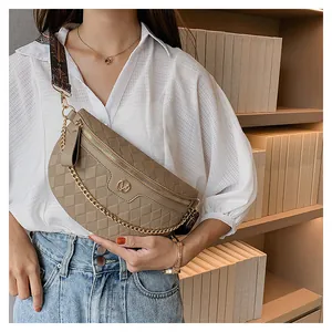 Detail der khakifarbenen Stepptasche mit Goldkette und Stoffgurt im Ethno-Stil