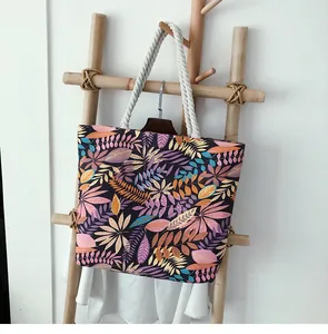 Détail d'un sac cabas en toile avec poignée en corde de coton et motifs de feuilles colorées