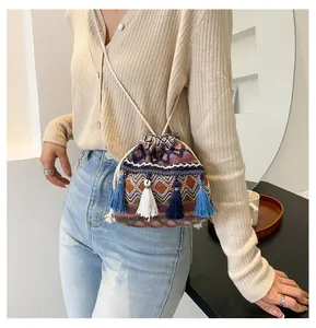 Détail du sac seau bohème tissé avec cordon de serrage, franges colorées et motifs ethniques