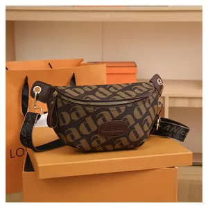 Detail of a brown monogram belt bag with gold hardware on an orange gift box