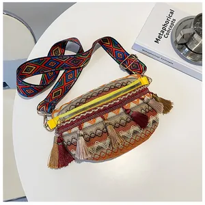 Detail of ethnic woven bag featuring colorful tassels and wide patterned shoulder strap