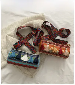 Macro detail of cylindrical woven bags with ethnic patterns and colorful fringe accents