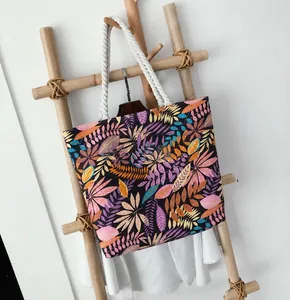 Detail of printed canvas tote bag with tropical leaf patterns and white rope handles