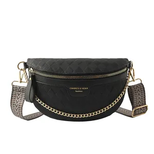 Black quilted crossbody bag with golden chain and wide patterned strap on white background