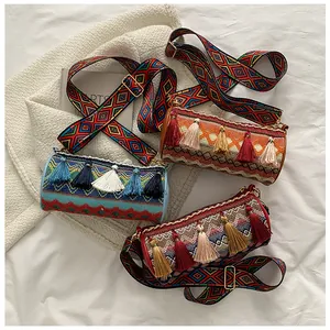 Detail of bohemian woven cylindrical bags with colorful tassels and patterned wide straps
