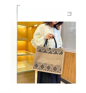 Detail view of ethnic jute tote bag with black geometric patterns and soft round handles