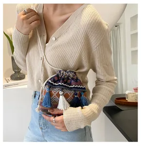 Détail d'un sac seau jacquard géométrique avec des glands colorés suspendus