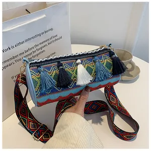 Close-up of bohemian tassel cylinder bag with colorful geometric patterns and wide strap