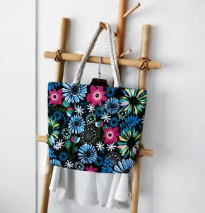 Detail of printed canvas tote bag with thick cotton rope handles on a wooden stand