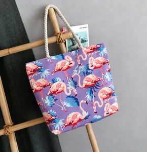 Detail of purple canvas tote bag with pink flamingo print and white cotton rope handles
