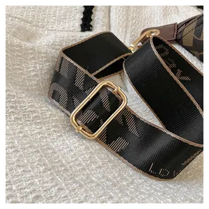 Detail of adjustable black woven strap with brown edges and lucky lettering for handbags