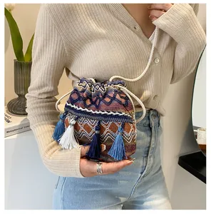 Détail d'un sac seau tissé bohème avec des motifs colorés et des glands élégants