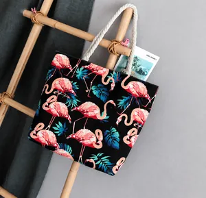 Detail of canvas tote bag with pink flamingo print and white thick rope handles