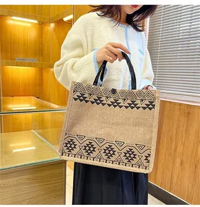 Close-up of ethnic totem print on linen tote bag with button closure and black handles