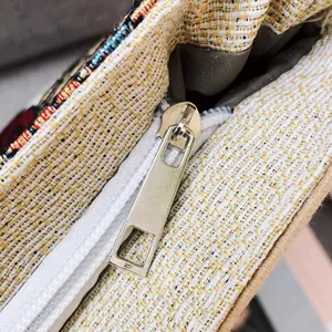 Dettaglio della cerniera in metallo dorato e della trama del tessuto della borsa tote