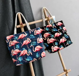 Detail of tropical flamingo and palm leaf print canvas tote bags with thick rope handles