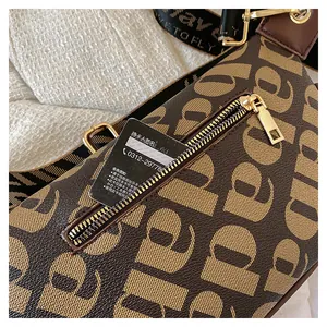 Detail of crossbody chest bag featuring monogram prints and front metal zipper pocket