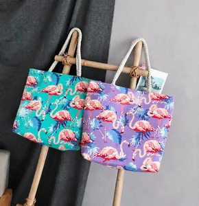 Detail of flamingo print canvas bags with white rope handles in mint green and lilac