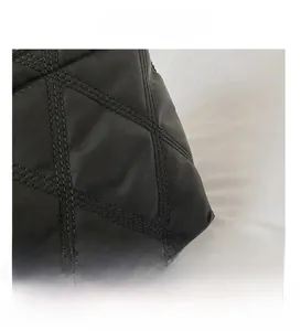 Detail view of black quilted nylon fabric with precision diamond stitching pattern