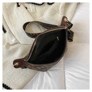 Detail view of the open crossbody bag with inner zipper pocket and woven letter strap