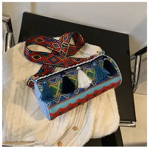 Macro detail of bohemian cylinder bag with colorful embroidery and long tassels