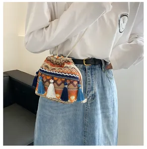 Détail du sac seau bohème avec motifs ethniques colorés et longues franges bleues