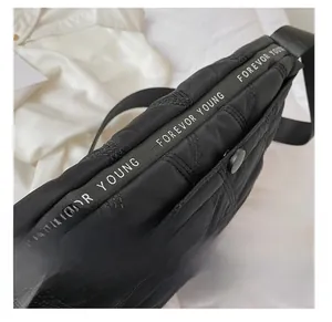 Detailed close-up of smooth zipper with Forever Young strap on black quilted bag