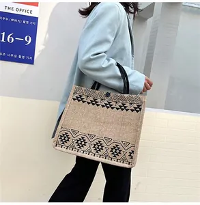 Detailed texture of jute tote bag with ethnic geometric pattern and black sturdy handles