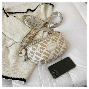 Detailed view of cream leather fanny pack with brown letter patterns and wide strap