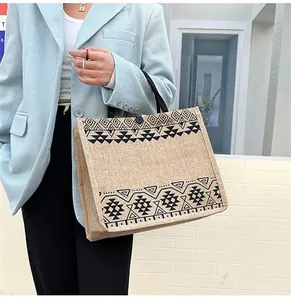 Ethnic style linen tote bag with geometric print held by a model in casual office wear