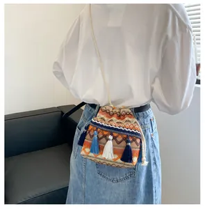 Détail du sac seau bohème avec des glands colorés et des motifs géométriques