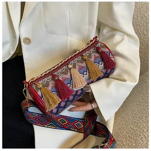 Detail of woven cylinder bag with colorful tassels and ethnic pattern wide strap