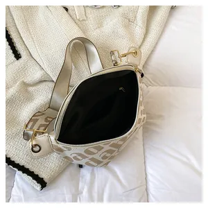 Detail view of the cream canvas waist bag interior with black lining and inner pocket