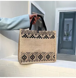 Close-up of jute tote bag featuring ethnic geometric patterns and sturdy black handles
